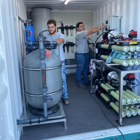 Photo of Elemental Water Makers & partners team with some equipment for an off-grid solar-powered seawater desalination solution. Photo: Elemental Water Makers.