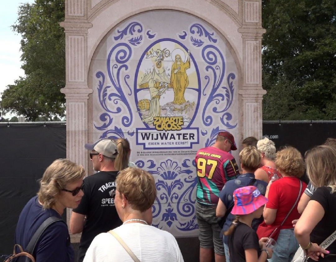 Visitors draw water from beneath the festival grounds