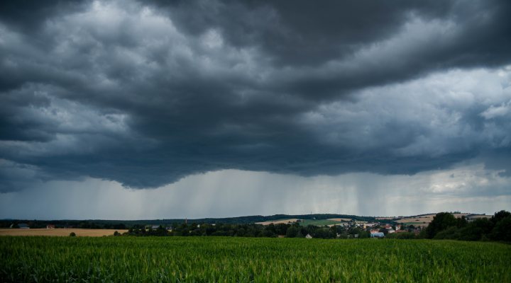 Thunder clouds and rain above landscape