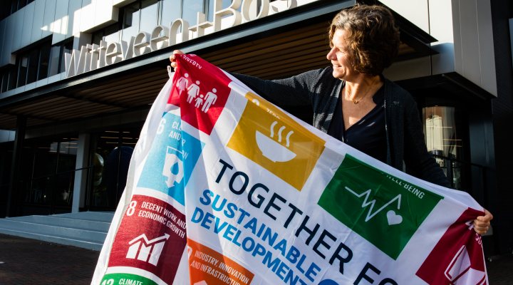 CEO Karin Sluis of Wittenveen+Bos holds a flag of the UN Sustainable Development Goals