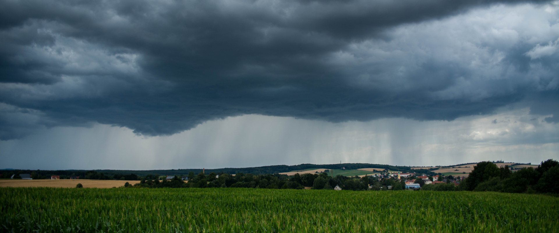 Thunder clouds and rain above landscape